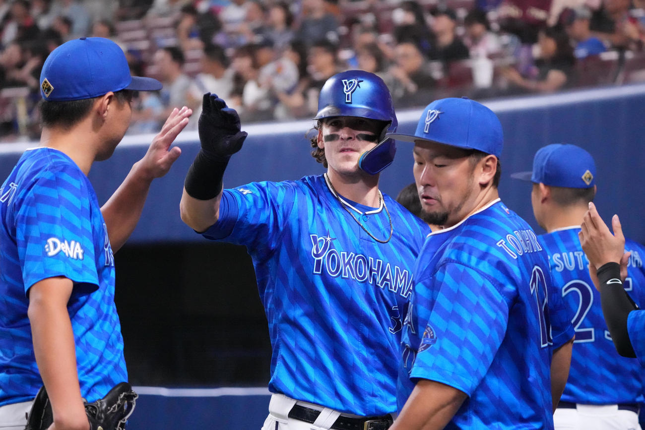 中日対DeNA 1回表DeNA1死一塁、中前打を放ちナインとタッチをするオースティン（中央）（撮影・森本幸一）