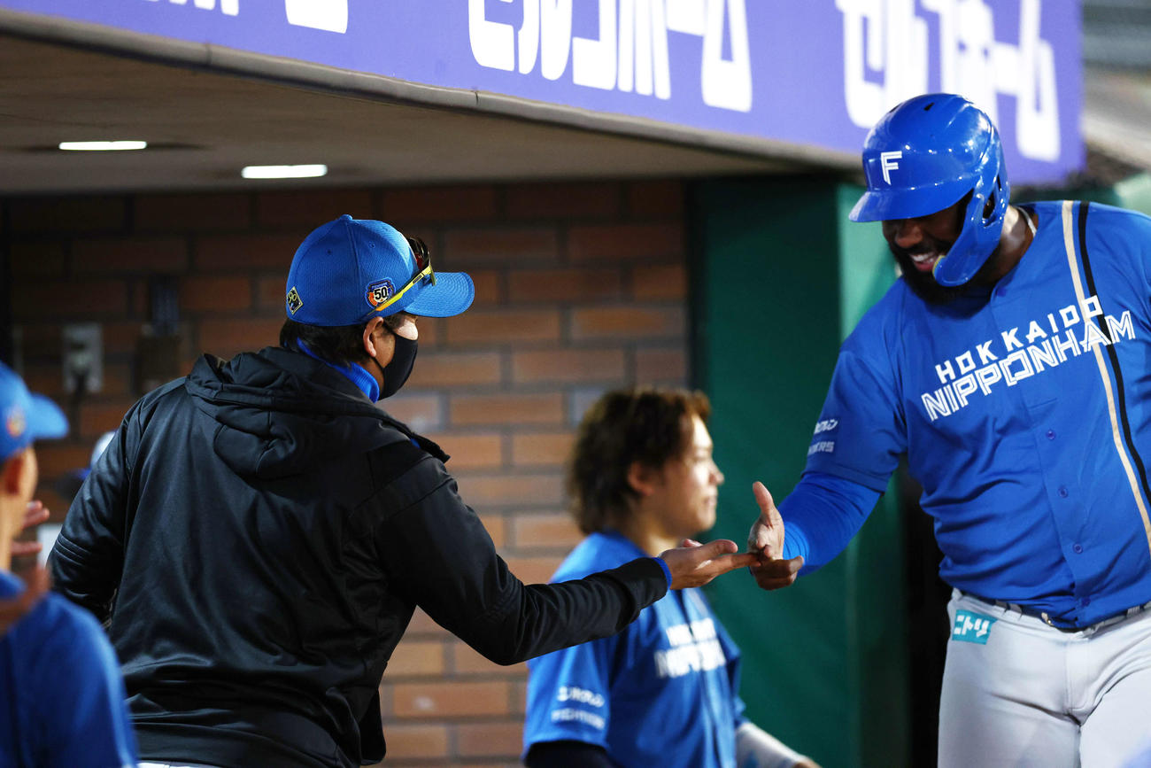楽天対日本ハム　1回表日本ハム2死一、二塁、上川畑の適時二塁打で生還するレイエス（右）を迎える新庄監督（撮影・河田真司）