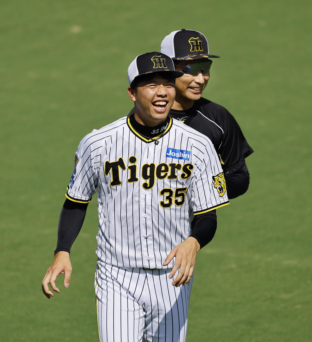 ウオーミングアップで笑顔を見せる阪神才木（撮影・藤尾明華）