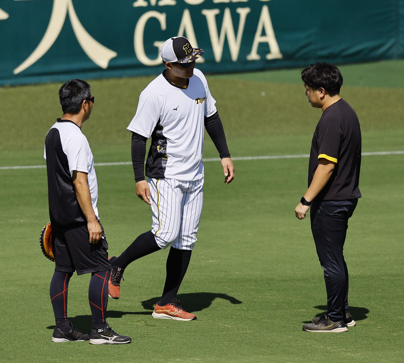 ウオーミングアップを終え、平田コーチ（右）と話をする阪神森下（撮影・藤尾明華）