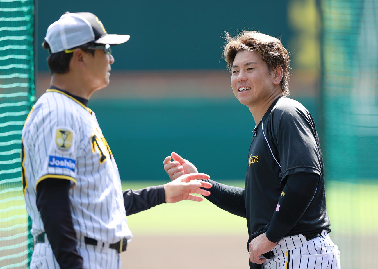 阪神梅野（右）はリラックスした表情で平田ヘッドコーチと話す（撮影・上山淳一）