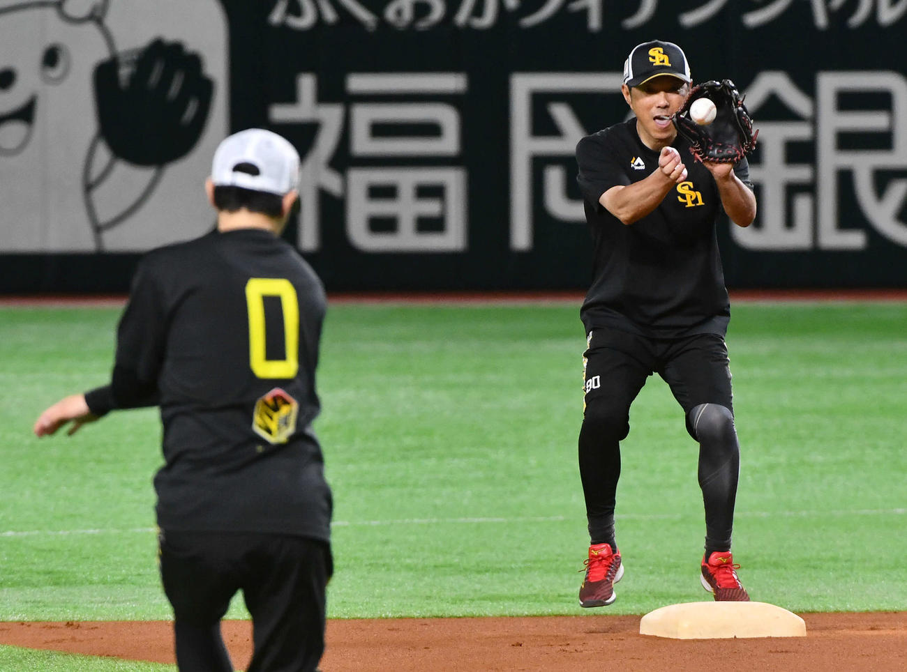 ノックで遊撃を守る川瀬（左）からの送球を二塁で受ける小久保監督（撮影・岩下翔太）