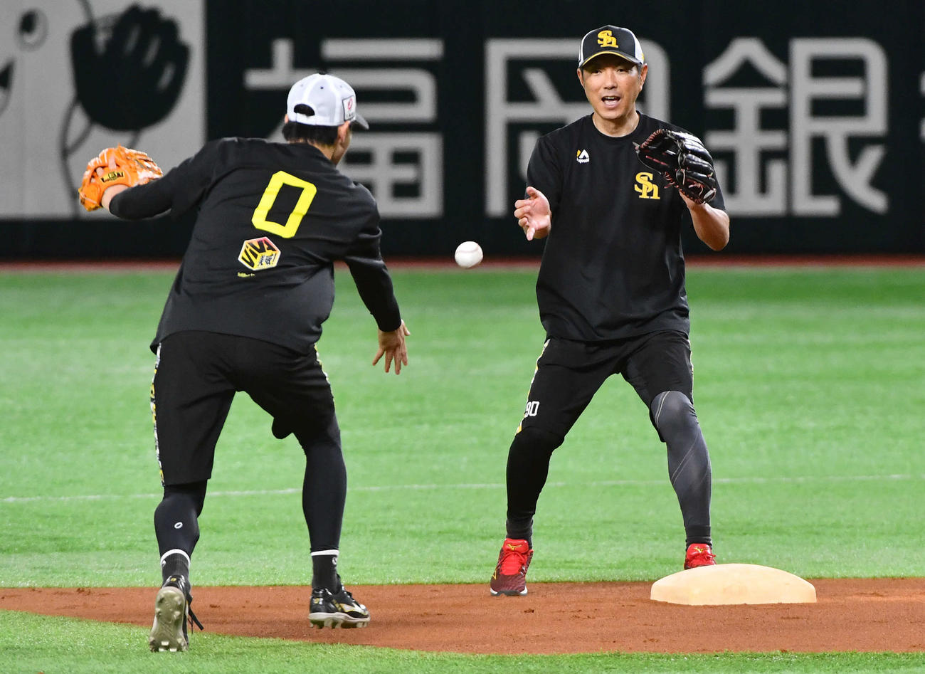 ノックで遊撃を守る川瀬（左）からの送球を二塁で受ける小久保監督（撮影・岩下翔太）