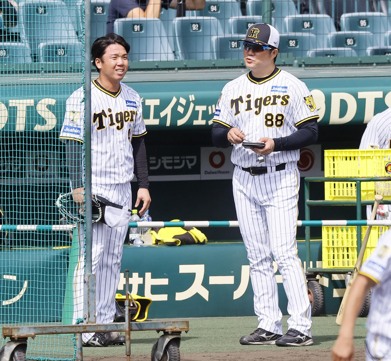 シート打撃の登板を終え、安藤コーチ（右）と話をする阪神村上（撮影・藤尾明華）