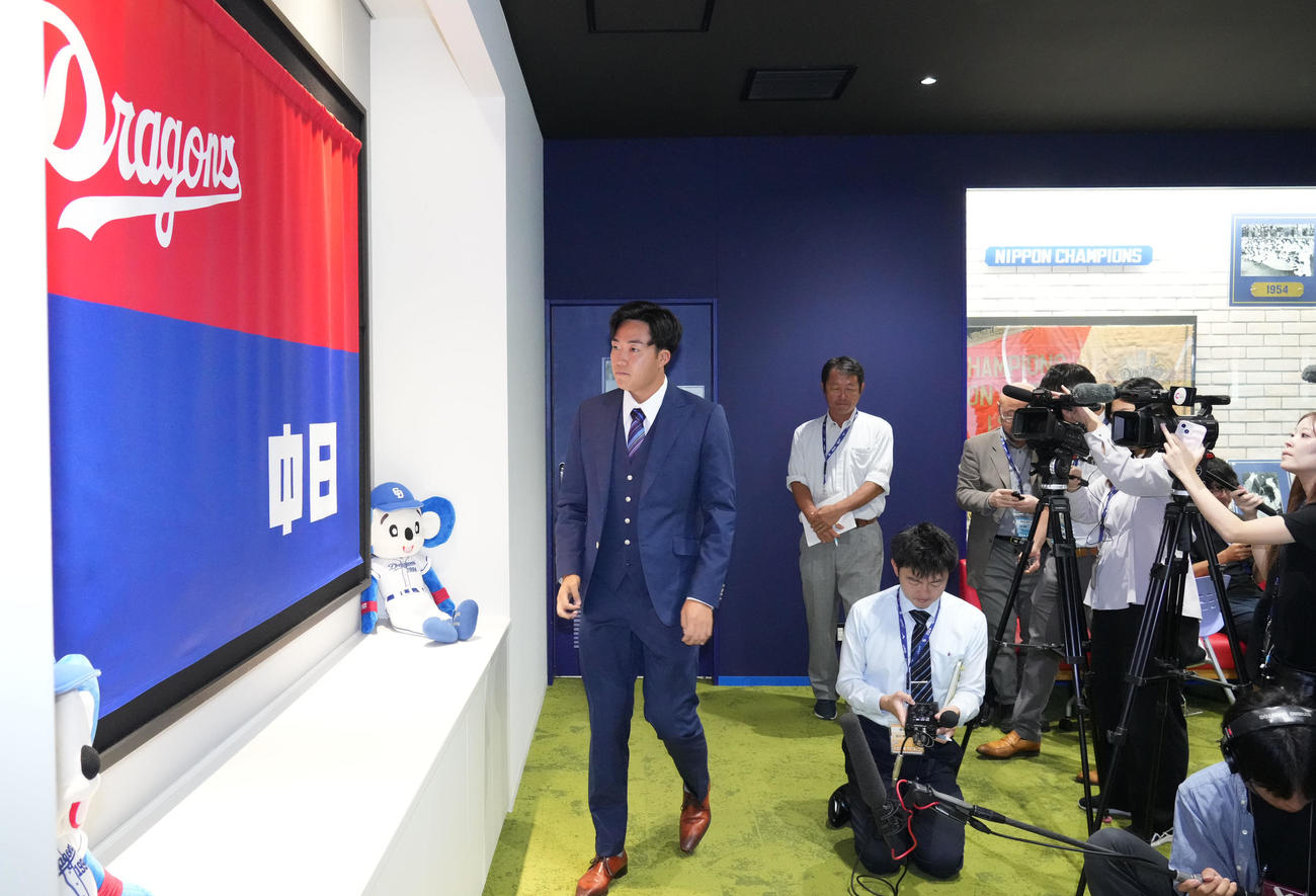 球団旗を見つめながら取材対応を受ける上田（左）（撮影・森本幸一）