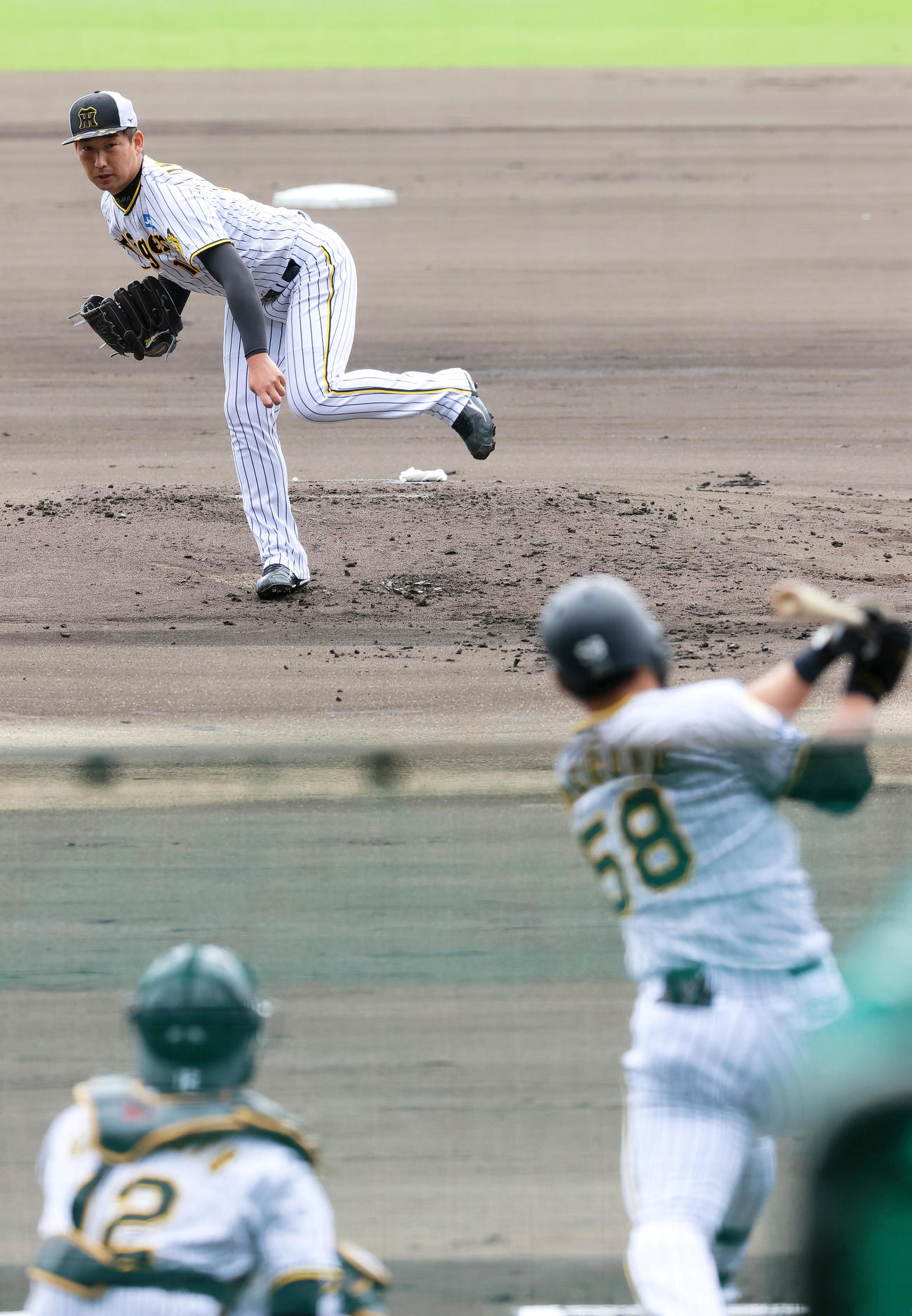 シート打撃で阪神前川（手前）に投球する阪神岩崎（撮影・上山淳一）