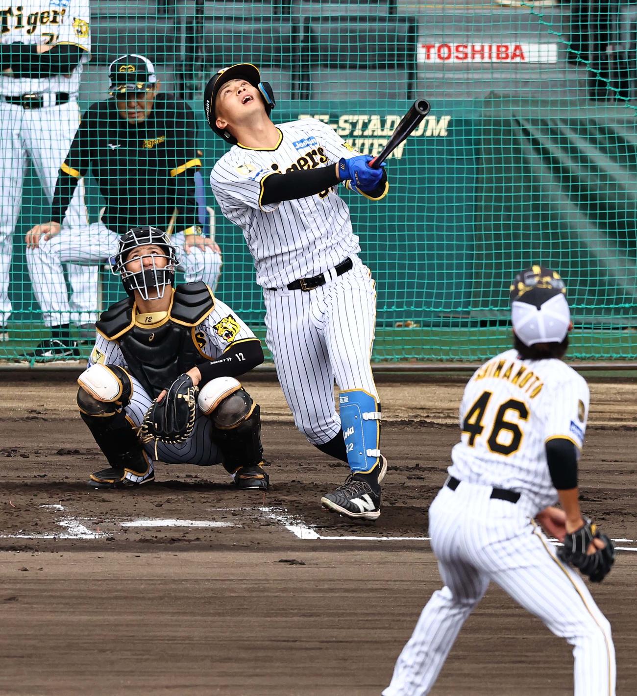 シート打撃で二飛を打ち上げる井上。後方は岡田監督（撮影・上田博志）