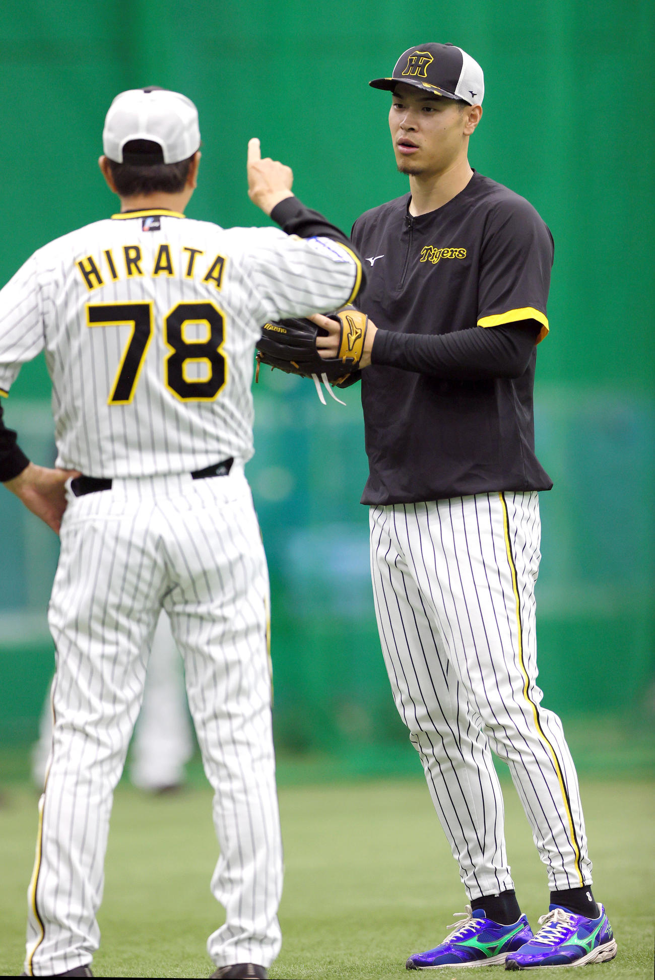 室内で阪神平田ヘッドコーチ（左）の話を聞く阪神佐藤輝（撮影・上山淳一）