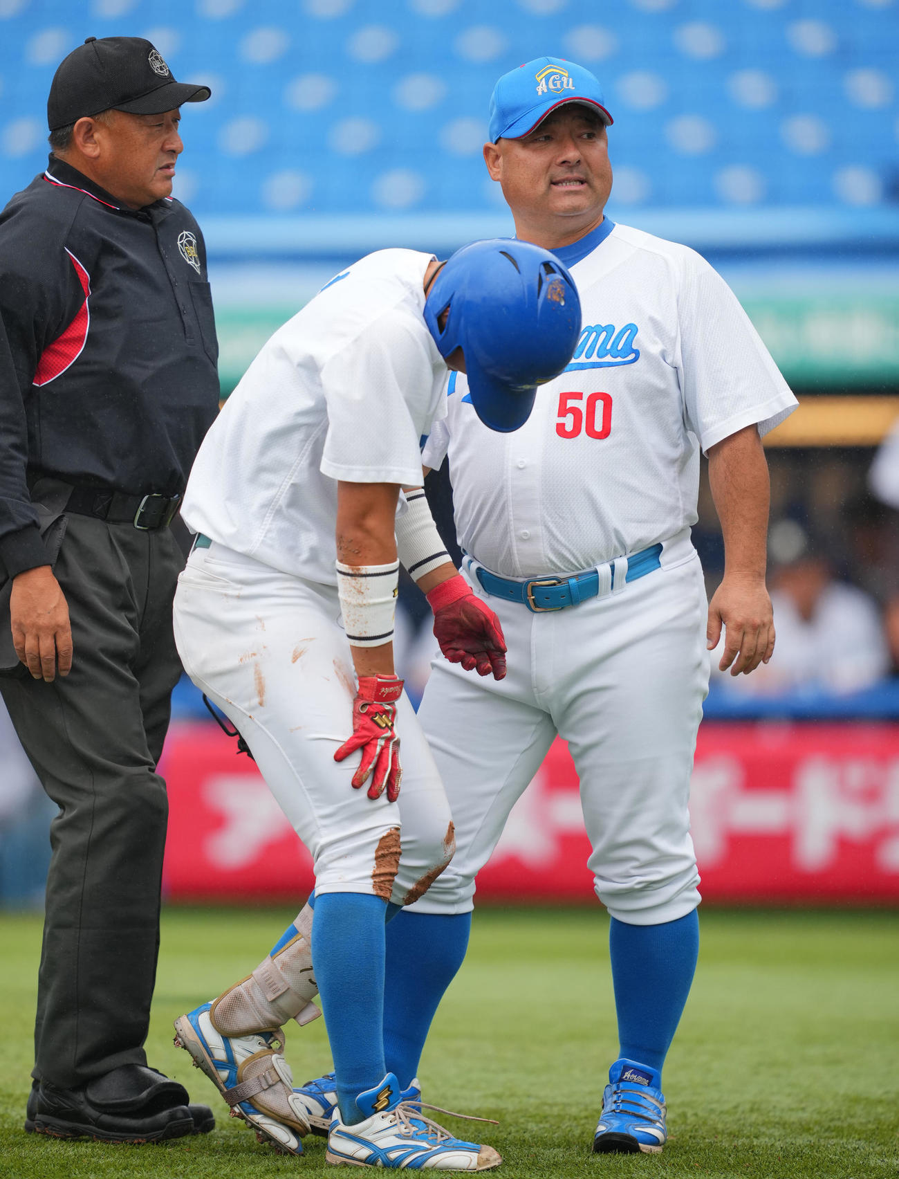 青学大対亜大　1回表青学大2死二塁、左手に死球を受けベンチに向かう佐々木（中央）の状態を確認する安藤監督（撮影・垰建太）