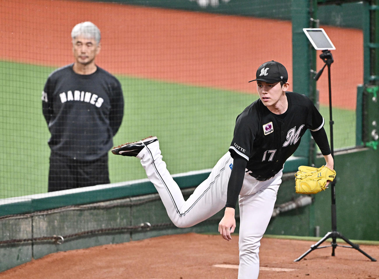 西武対ロッテ　試合前練習でロッテ吉井理人監督（後方）から見守られながら調整する佐々木朗希（2024年9月29日撮影）