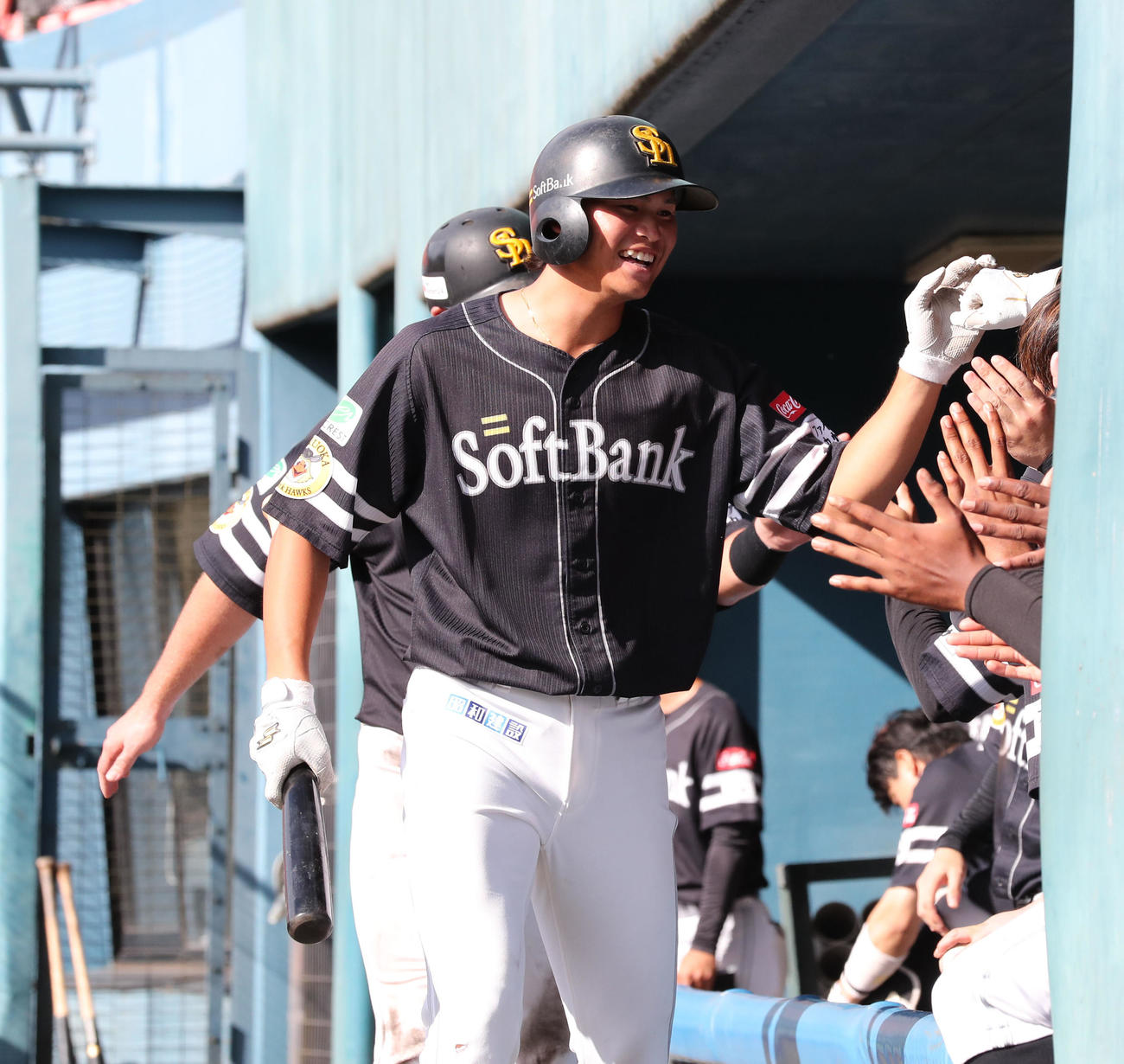 ロッテ対ソフトバンク　9回表ソフトバンク1死一塁、笹川は右越えに2点本塁打を放ちベンチのナインとハイタッチ（撮影・梅根麻紀）