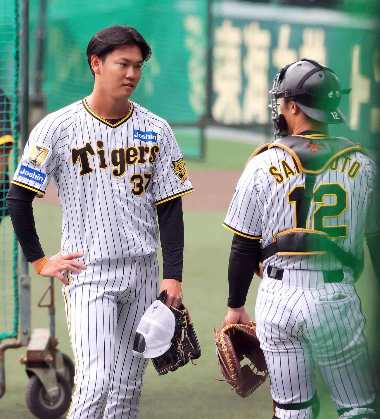 シート打撃で投球を終え捕手坂本（右）の話を聞く阪神及川（撮影・上山淳一）