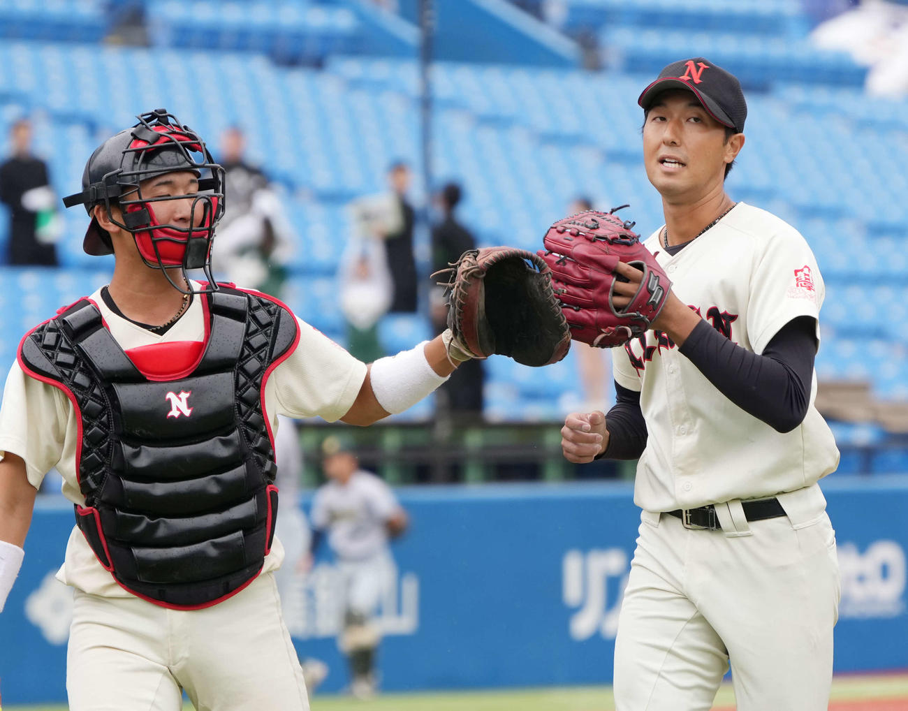 東農大対日大　3回の投球を終え南條（左）とグラブタッチする日大先発の市川（撮影・小沢裕）