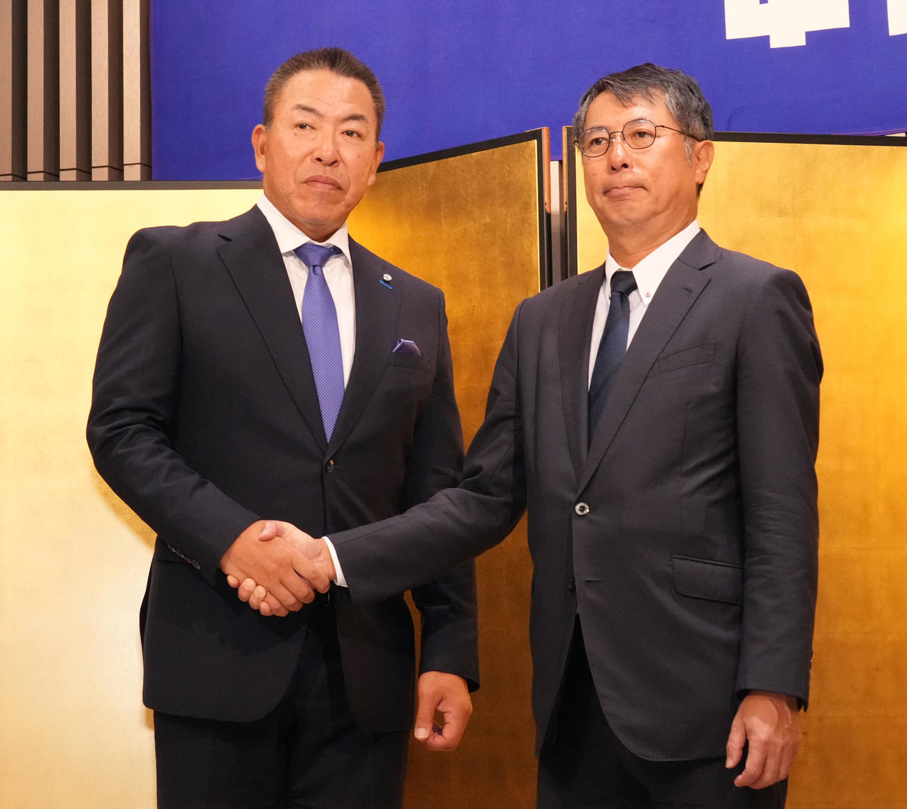 1軍監督就任を受諾し大島オーナーと握手を交わす井上監督（左）（撮影・森本幸一）