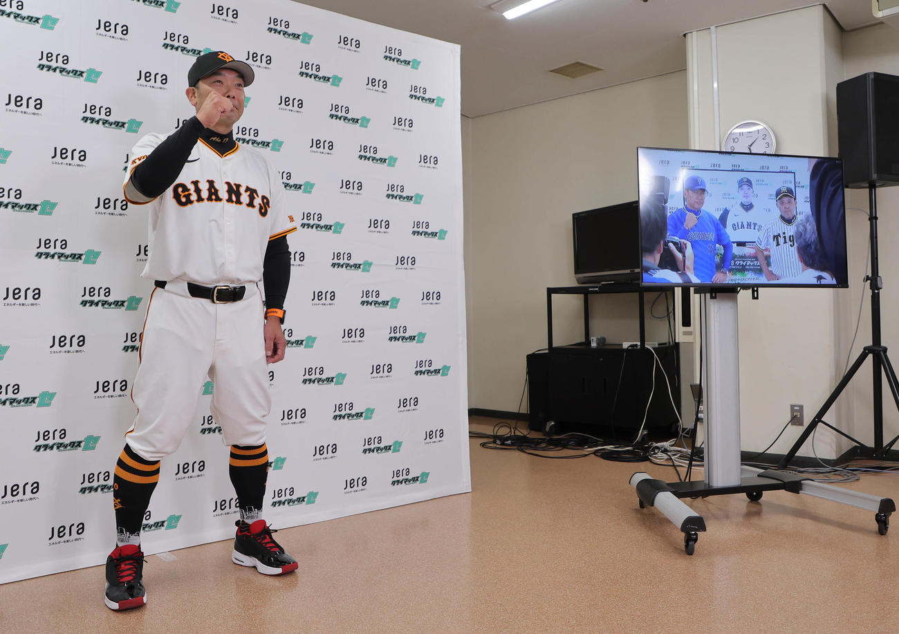 ガッツポーズする巨人阿部監督。ディスプレイに写るのは阪神岡田監督（右）とDeNA三浦監督