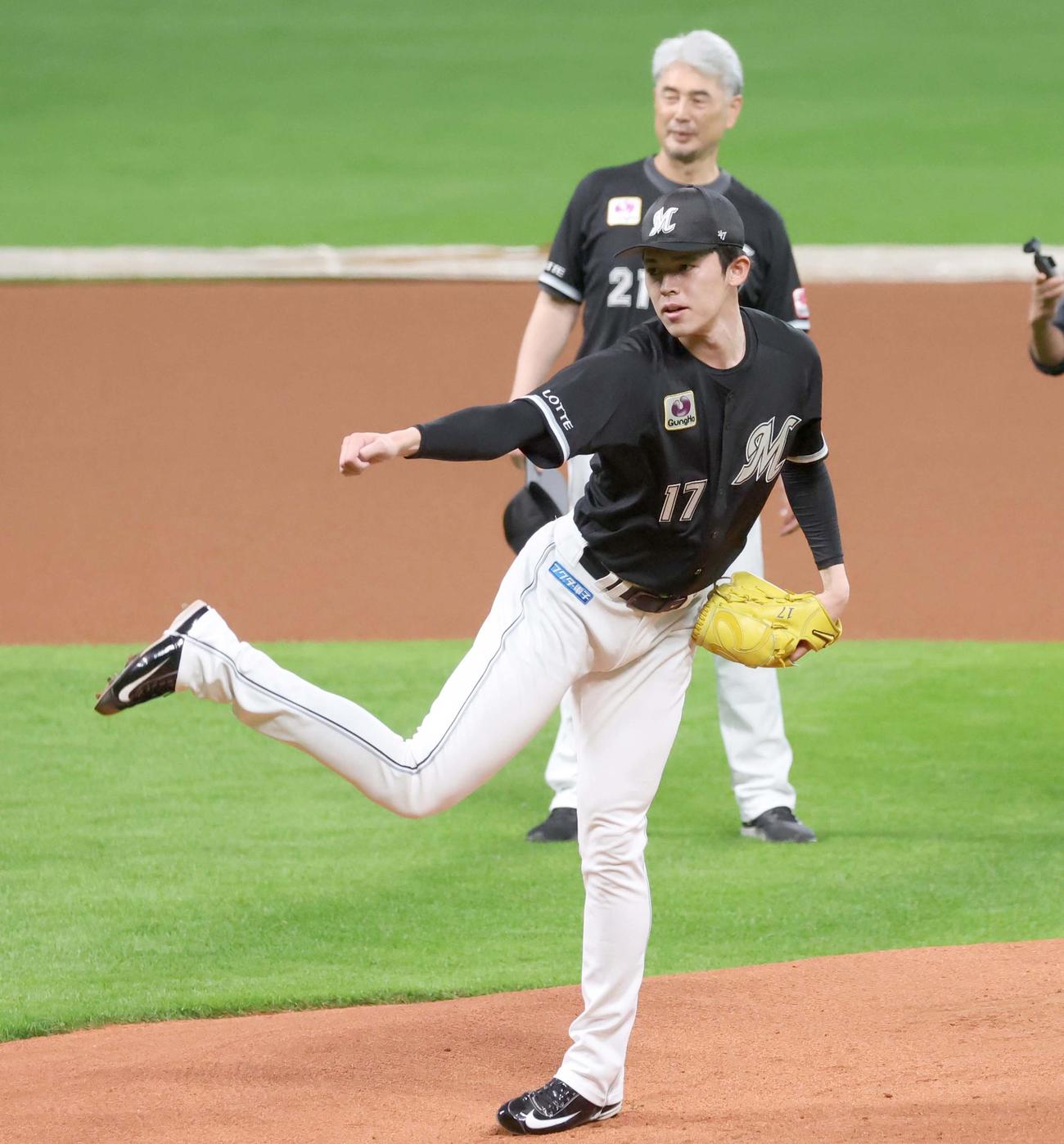 マウンドで投球する佐々木。後方は投球を見つめる吉井監督（撮影・黒川智章）