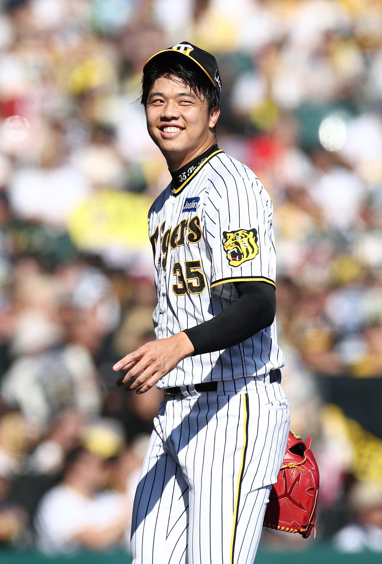 阪神対DeNA 1回表DeNA2死満塁、桑原を二飛に仕留め、笑顔を見せながらベンチへ戻る才木（撮影・前田充）