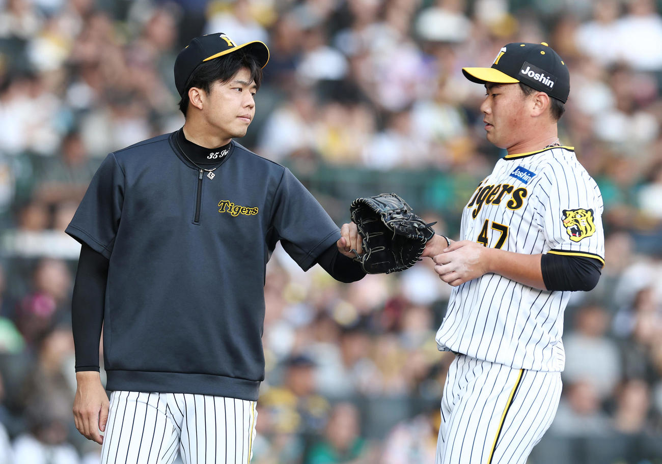阪神対DeNA 7回表DeNA1死一、三塁、降板した桐敷（右）を迎える才木（撮影・前田充）