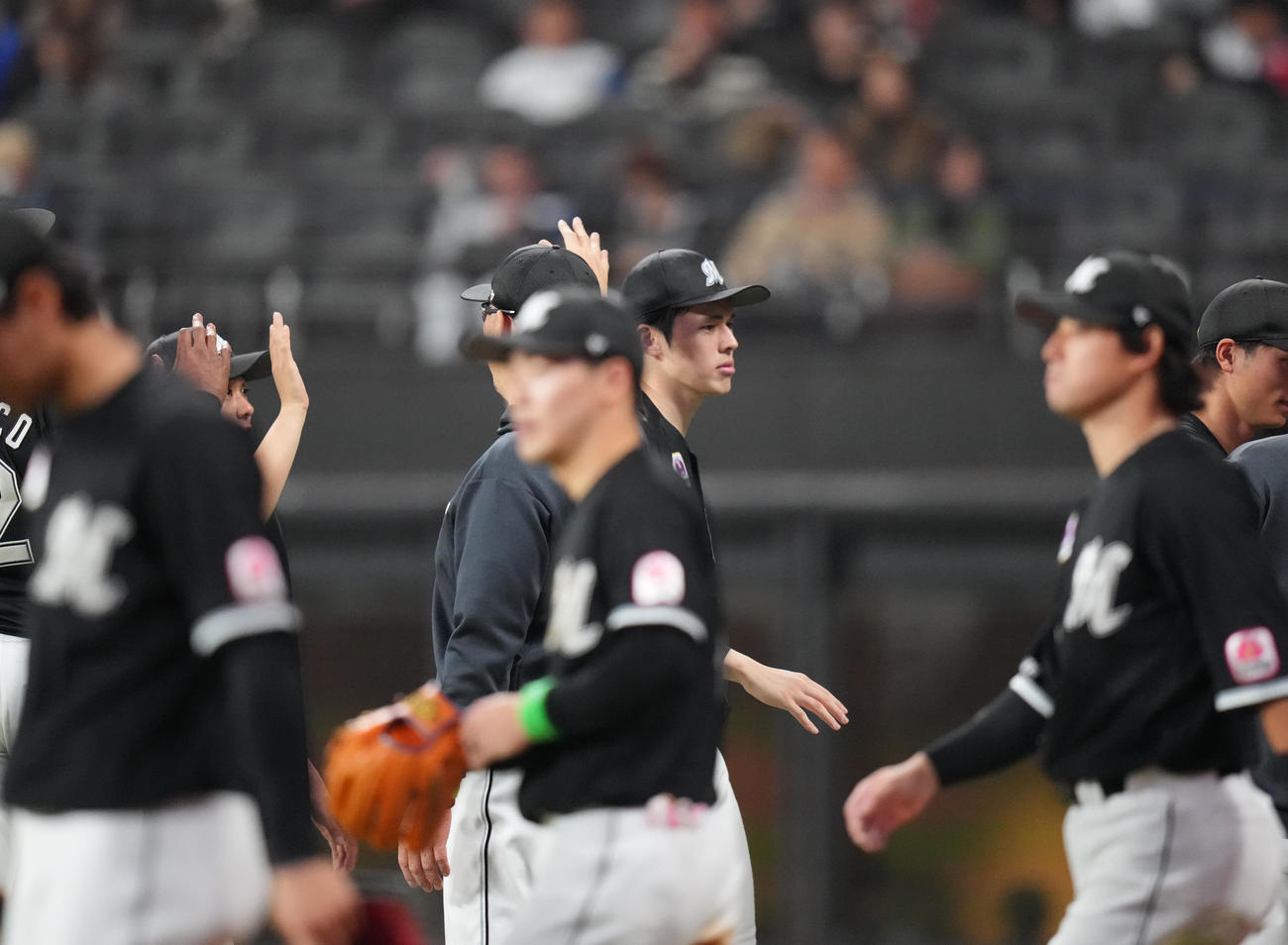 日本ハム対ロッテ　試合後、吉井監督（後方中央左）から頭をポンっとたたかれる佐々木（撮影・狩俣裕三）