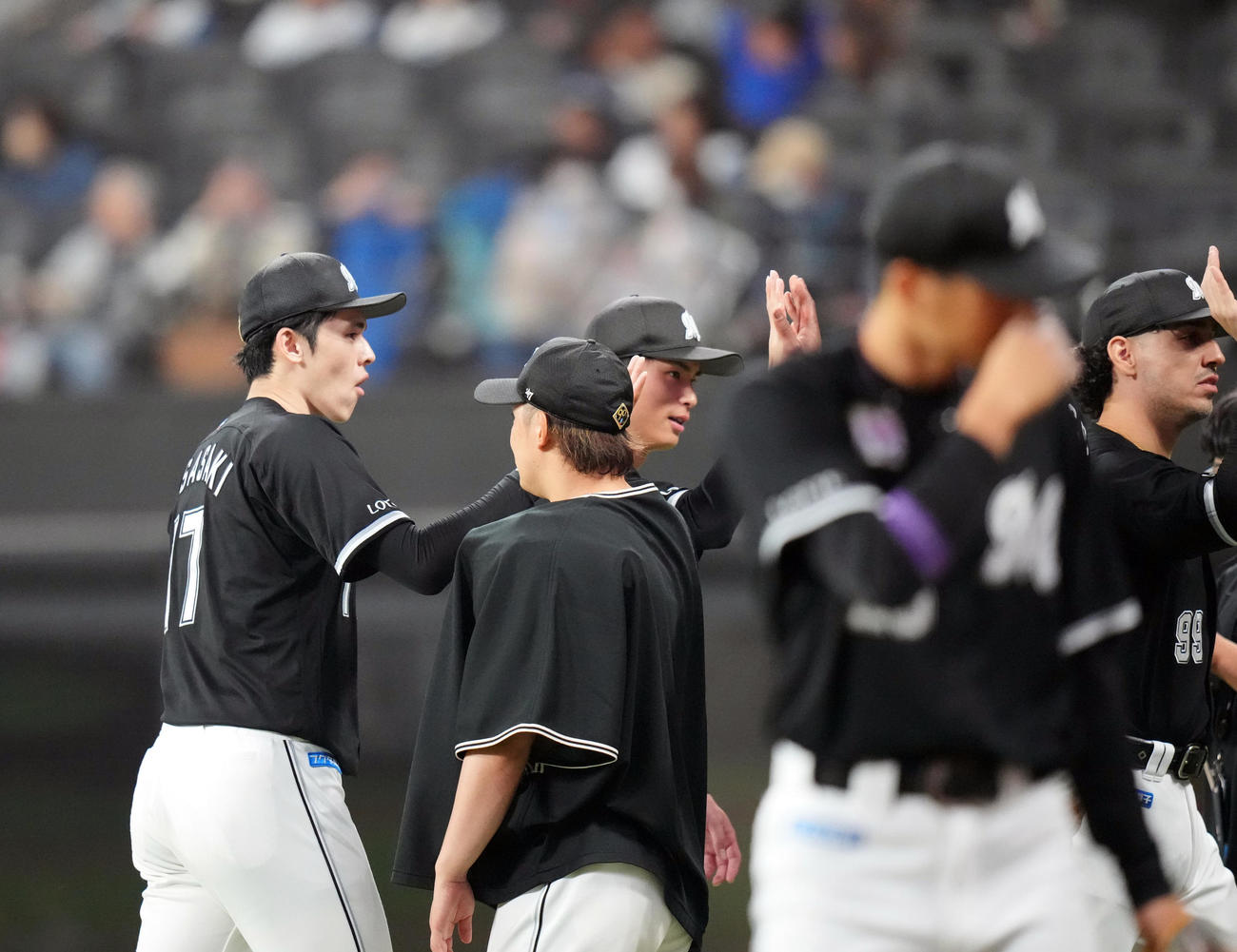 日本ハム対ロッテ　試合後、チームメートとタッチを交わす佐々木（左端）（撮影・狩俣裕三）