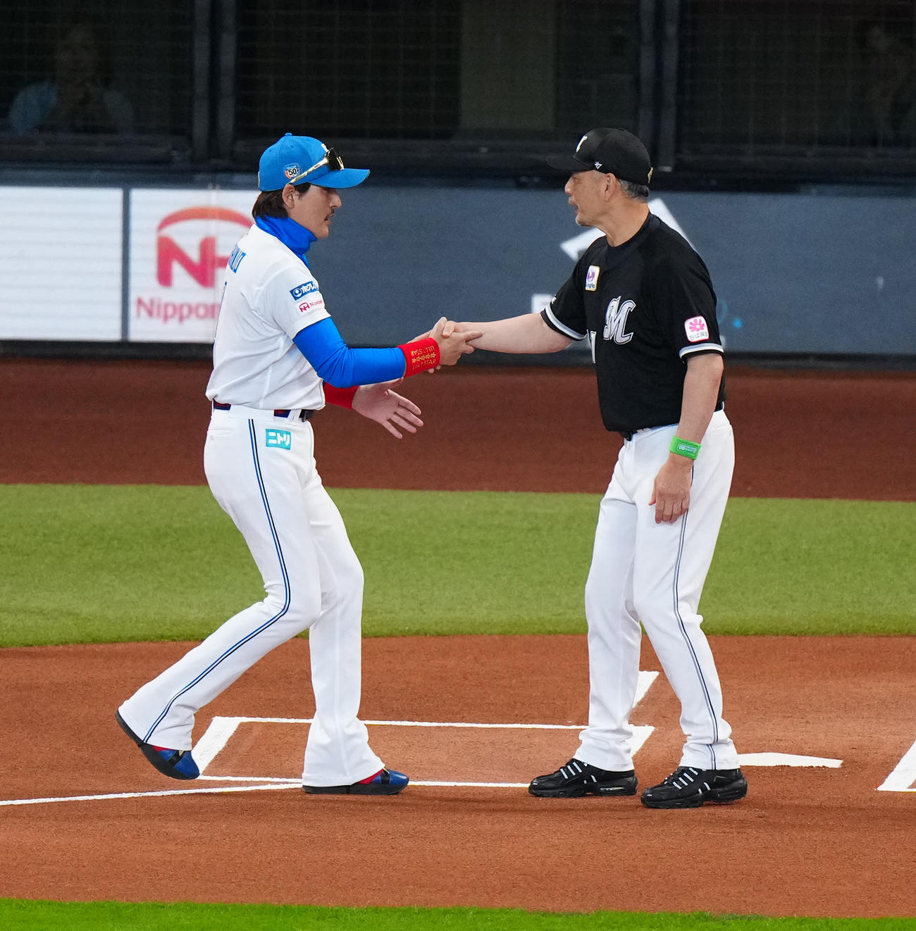 日本ハム対ロッテ　試合前のセレモニーで握手を交わす日本ハム新庄監督（左）とロッテ吉井監督（撮影・江口和貴）