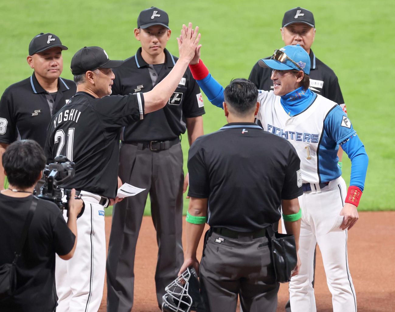 日本ハム対ロッテ　メンバー表交換で吉井監督とハイタッチする新庄監督（撮影・黒川智章）