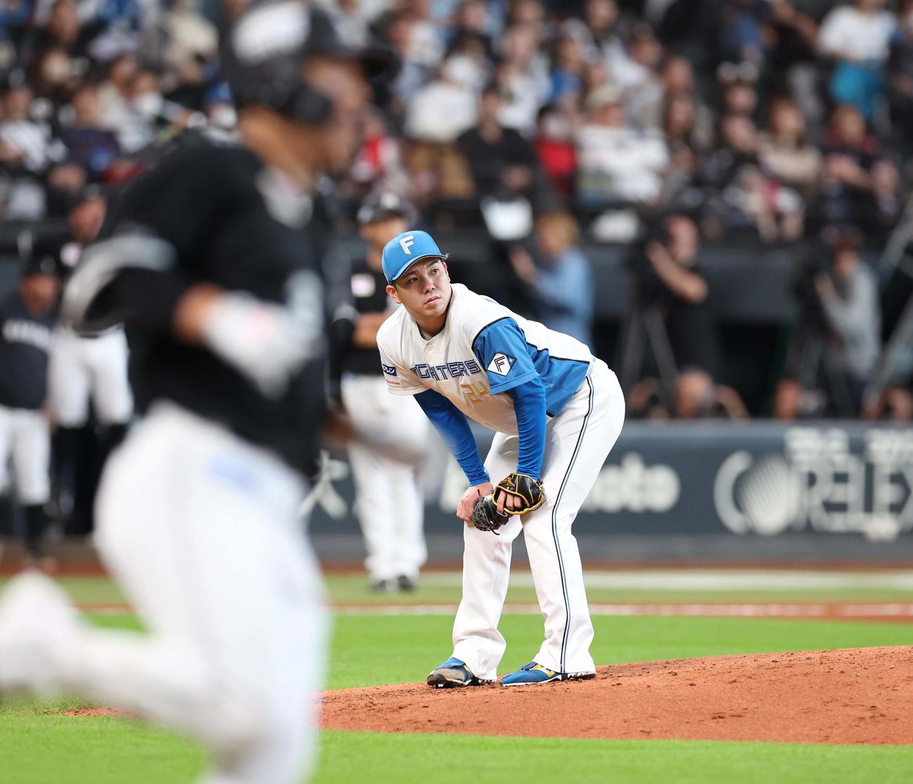 日本ハム対ロッテ　7回表ロッテ無死、角中（手前）に右越え本塁打を浴び肩を落とす金村（撮影・黒川智章）
