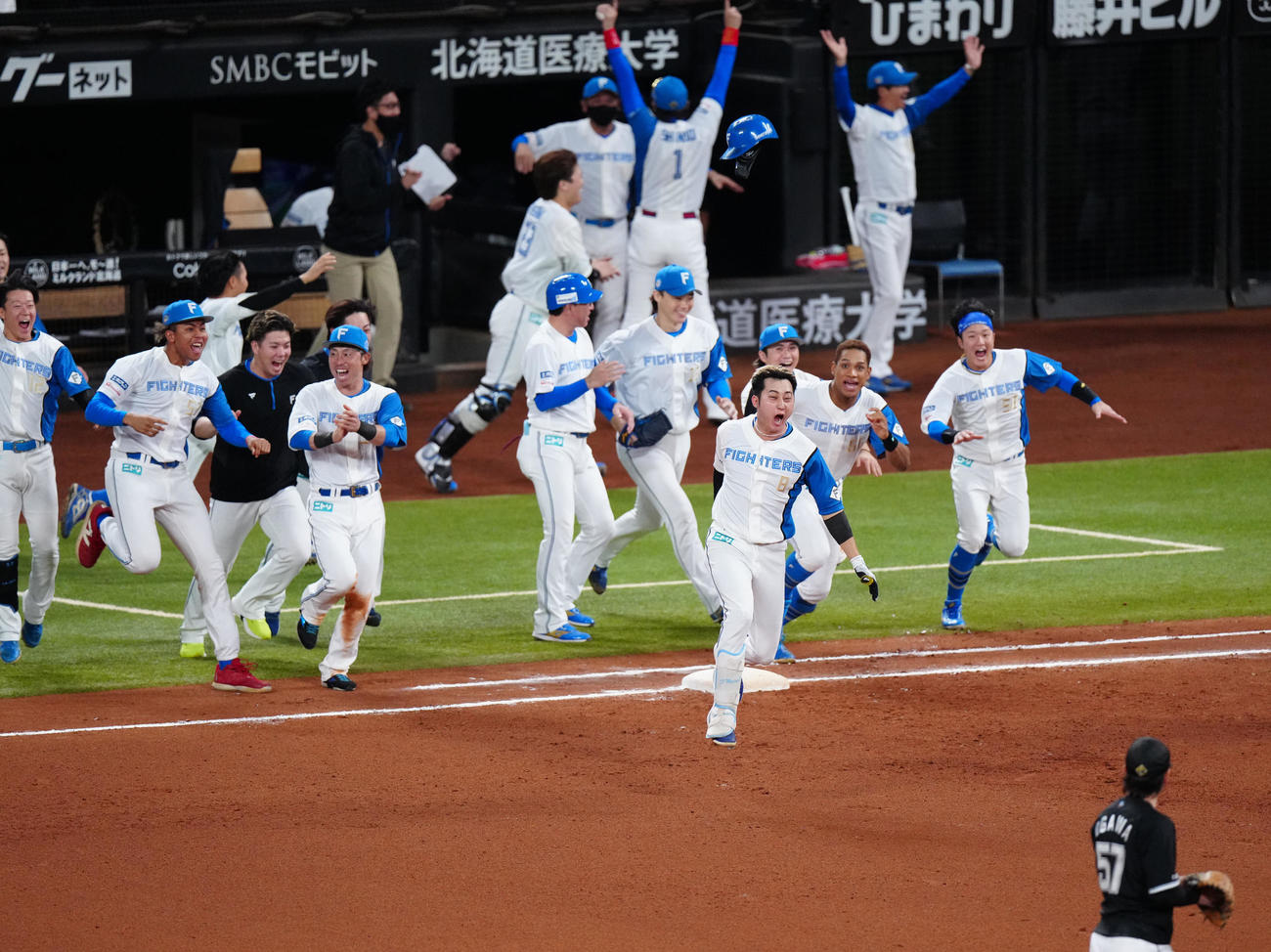 日本ハム対ロッテ　10回裏日本ハム2死一、三塁、サヨナラ適時打を放ち歓喜する浅間（手前右）（撮影・江口和貴）