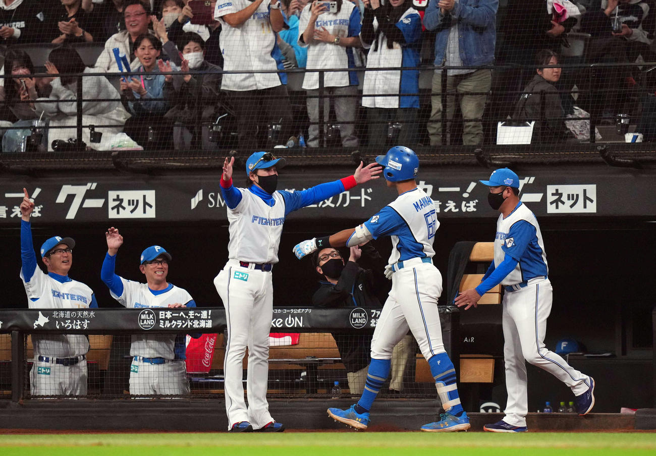 日本ハム対ロッテ　9回裏日本ハム1死、ソロ本塁打を放った万波（中央右）をハグで迎える新庄監督（撮影・狩俣裕三）