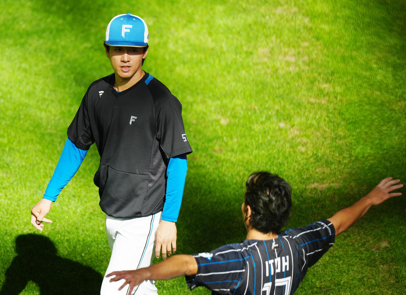 日本ハム対ロッテ　試合前練習中、日本ハム伊藤（手前）と言葉を交わす北山（撮影・江口和貴）