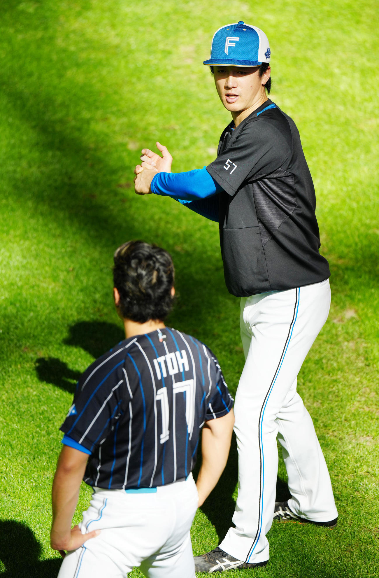 日本ハム対ロッテ　試合前練習中、日本ハム伊藤（手前）と言葉を交わす北山（撮影・江口和貴）