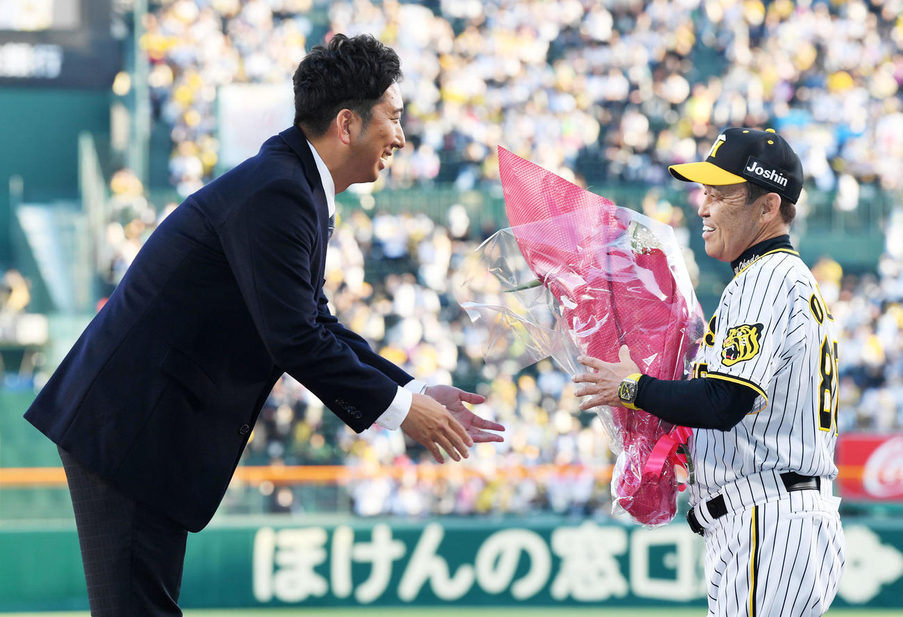 名球会ブレザー授与式で阪神岡田監督（右）から花束を受け取る藤川球児球団本部付SA（2023年撮影）