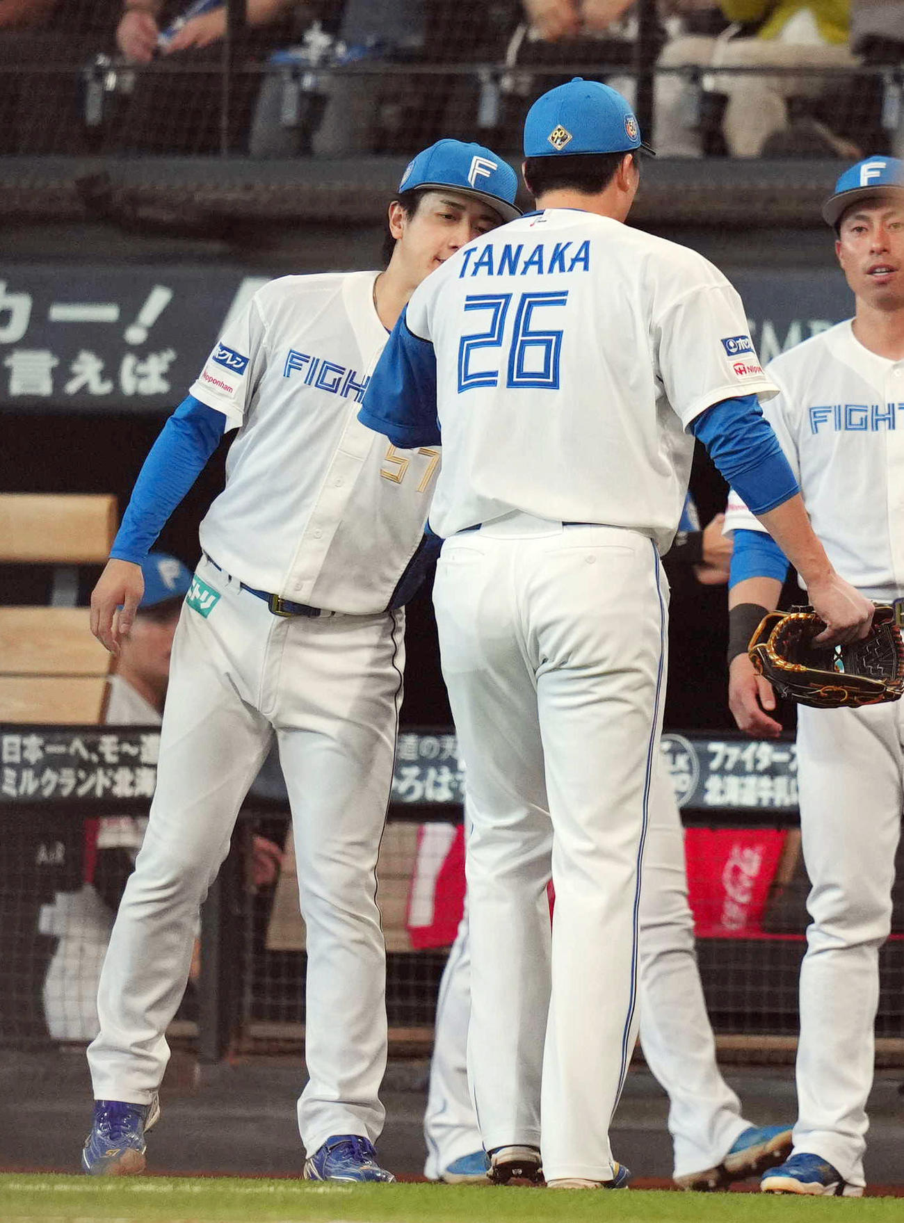 日本ハム対ロッテ　5回表を抑えた2番手の田中正（手前）を迎える先発北山（撮影・狩俣裕三）