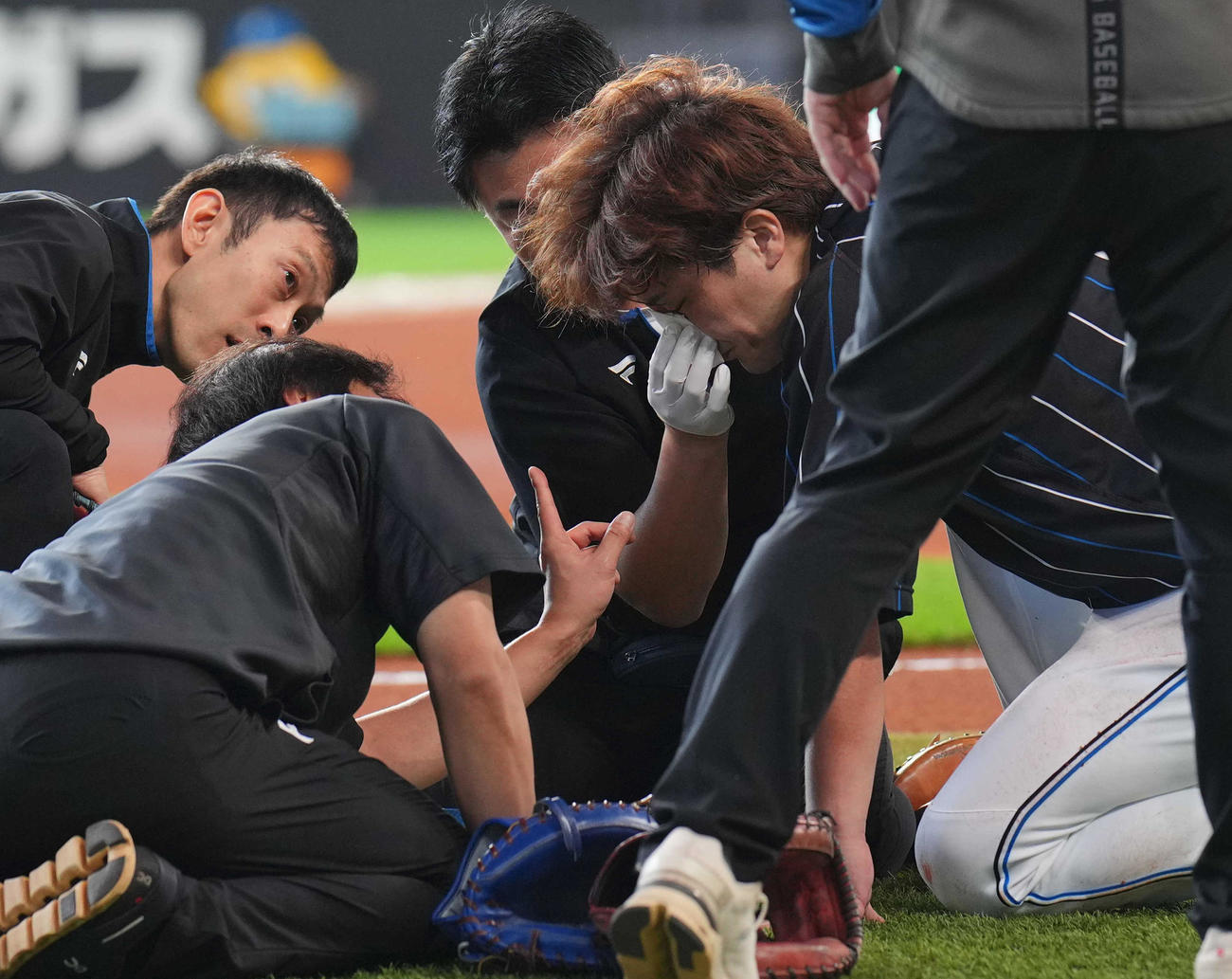 日本ハム対ロッテ　練習中、スタッフから手当される伏見（中央）（撮影・狩俣裕三）