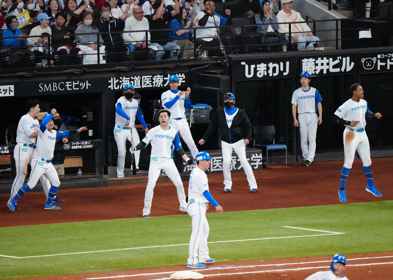 日本ハム対ロッテ　7回裏日本ハム2死一、二塁、水野（手前）が2点適時三塁打を放ち、ベンチを飛び出す選手たち（撮影・江口和貴）