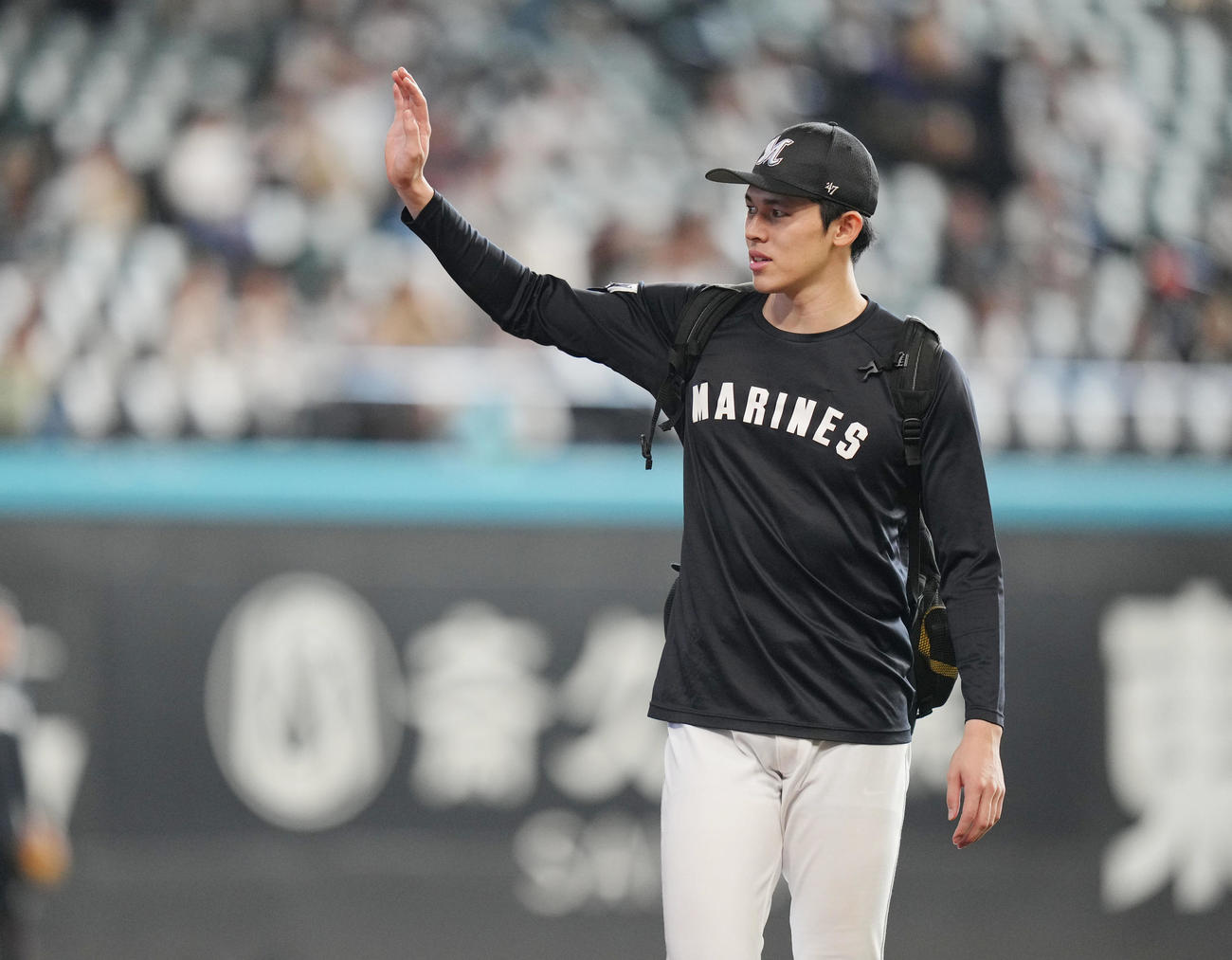 日本ハム対ロッテ　練習を終え、ファンに手を振りながら引き揚げる佐々木（撮影・狩俣裕三）