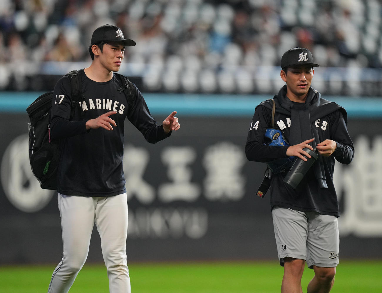 日本ハム対ロッテ　練習を終え、小島（右）と談笑しながら引き揚げる佐々木（撮影・狩俣裕三）