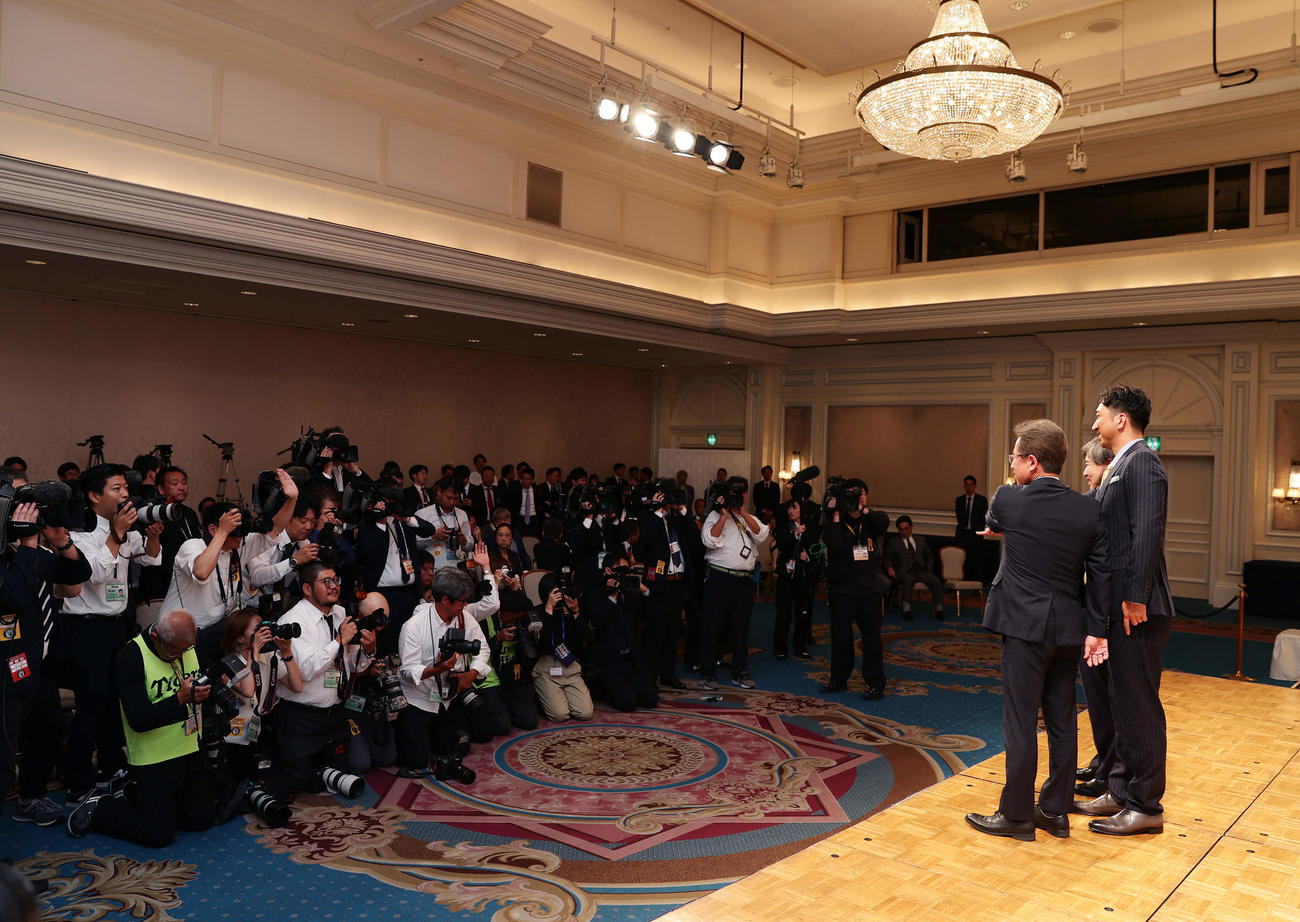 就任会見で多くの報道陣を前に手を合わせる、右から阪神藤川新監督、杉山オーナー、粟井球団社長（撮影・前田充）