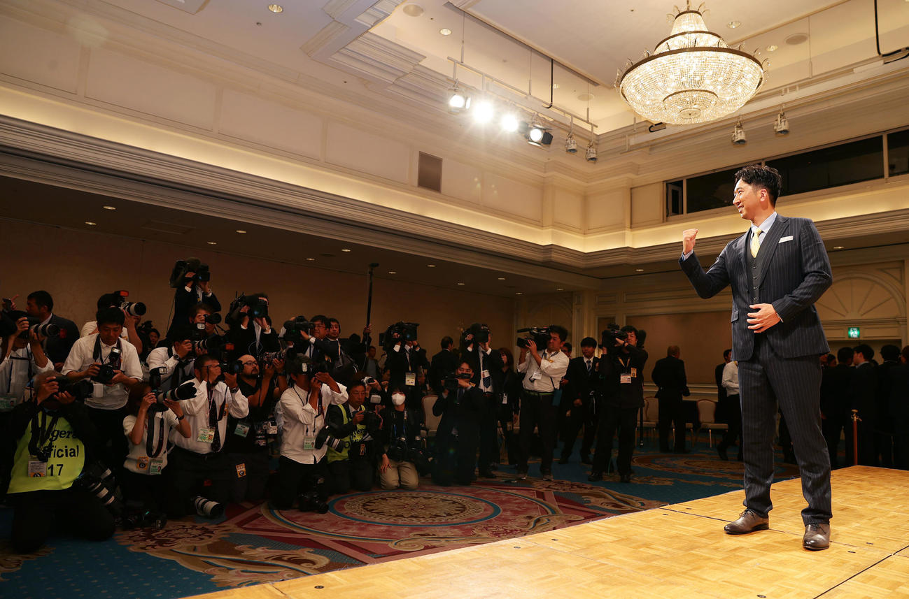 就任会見で多くの報道陣を前にガッツポーズする阪神藤川新監督（撮影・前田充）