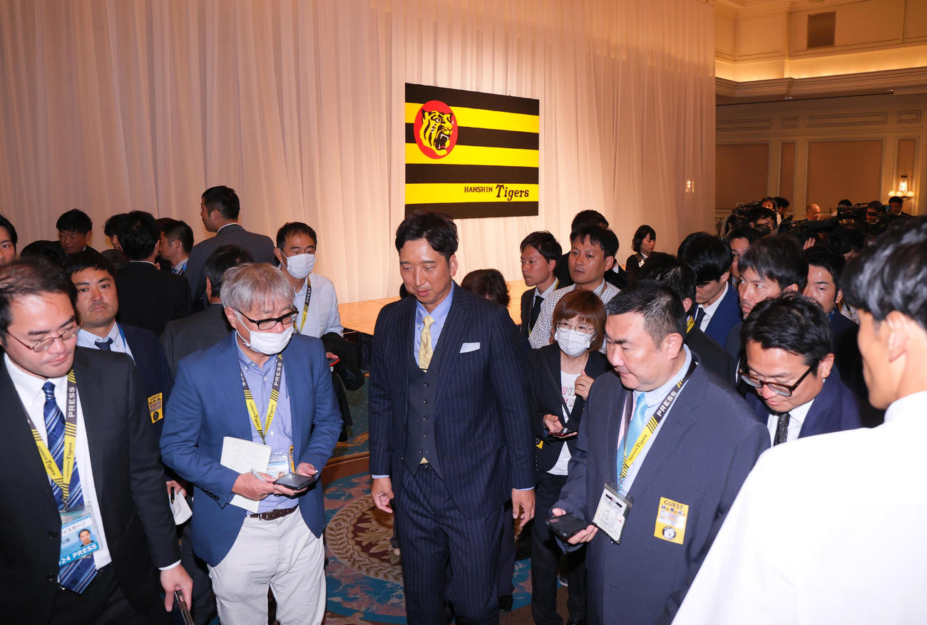 阪神藤川新監督（中央）は就任会見を終え報道陣に囲まれながら移動する（撮影・上山淳一）