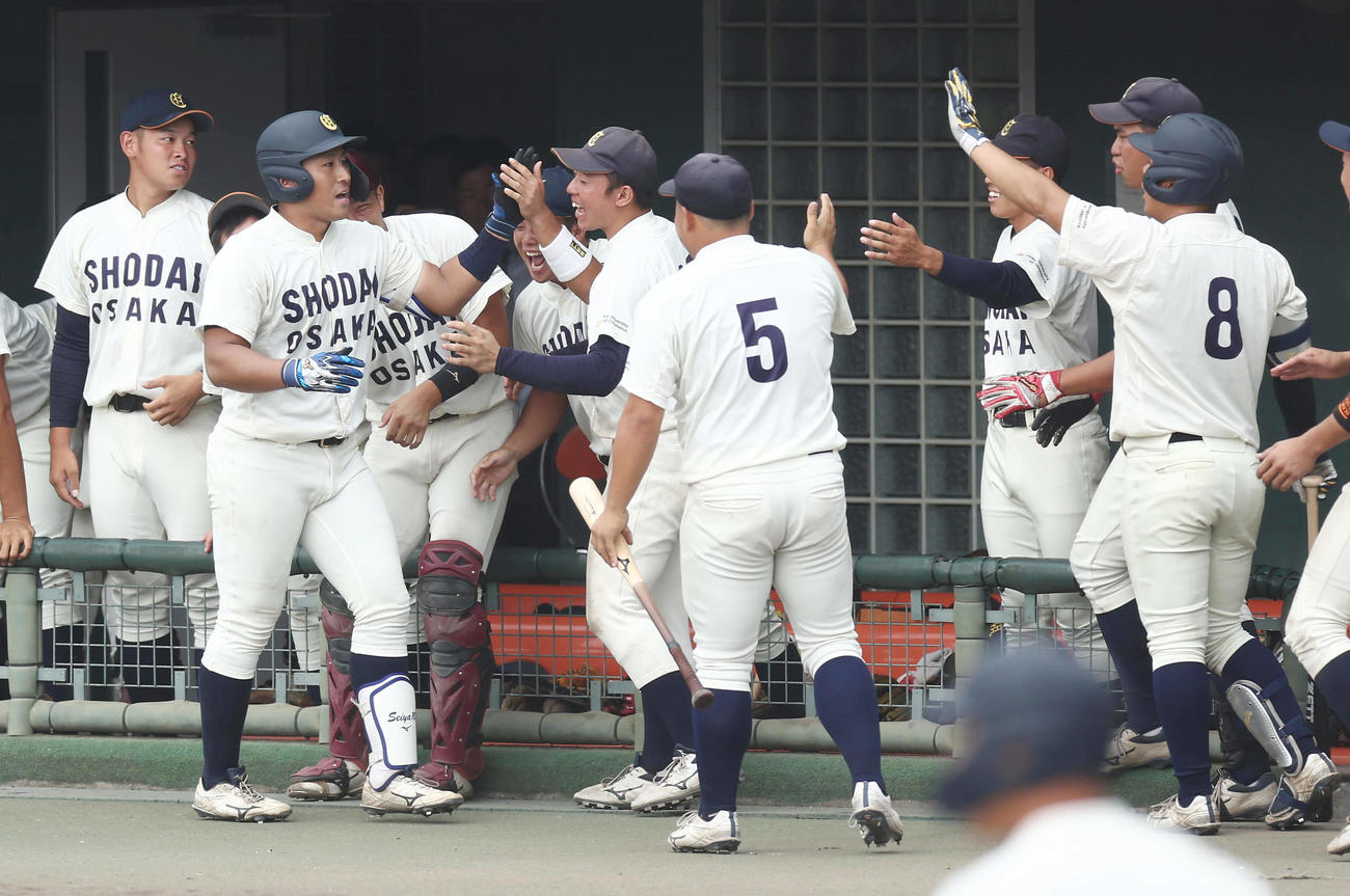 大経大対大商大　9回裏大商大無死一、二塁、犠打を決めナインに迎えられる渡部（左から2人目）（撮影・前田充）