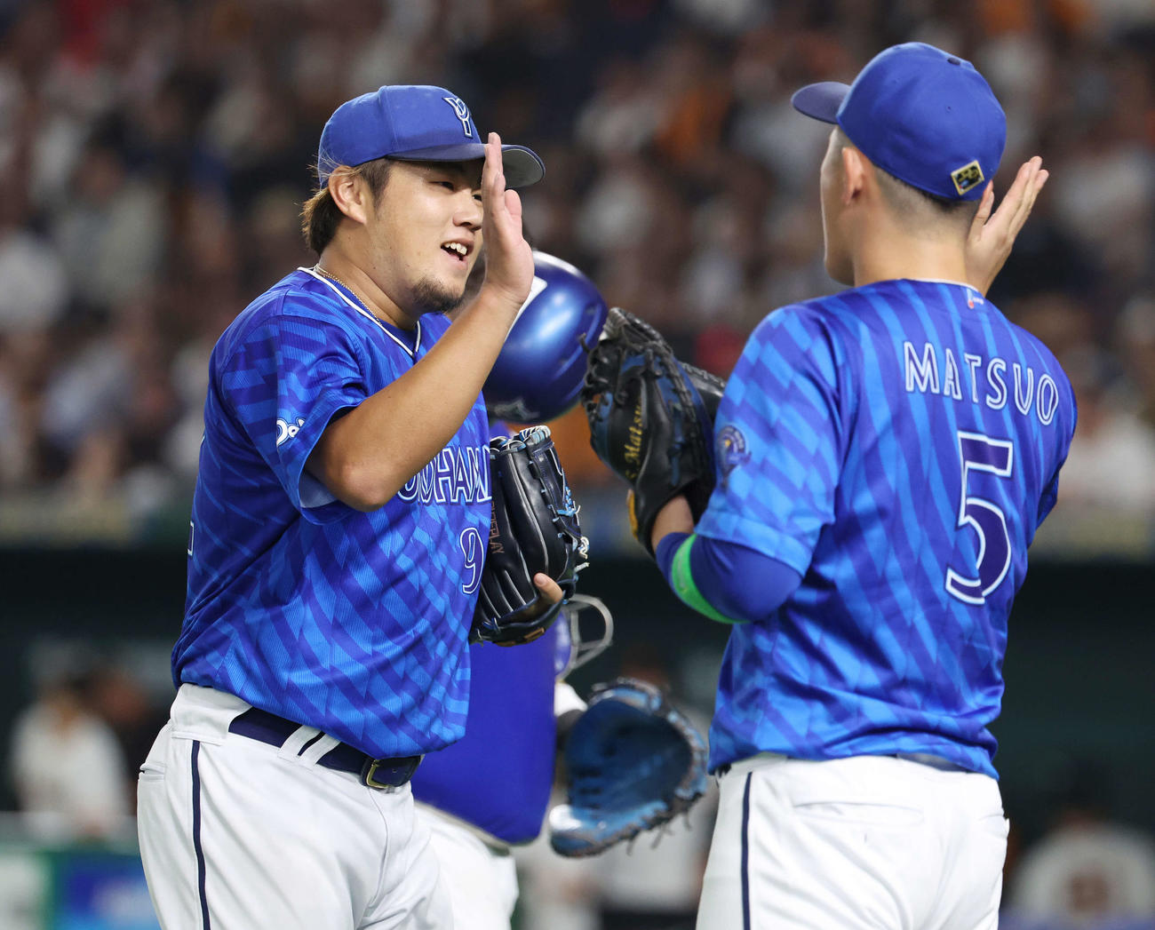 巨人対DeNA 8回裏を無失点に抑えチームメートとタッチを交わすDeNA堀岡（撮影・宮地輝）