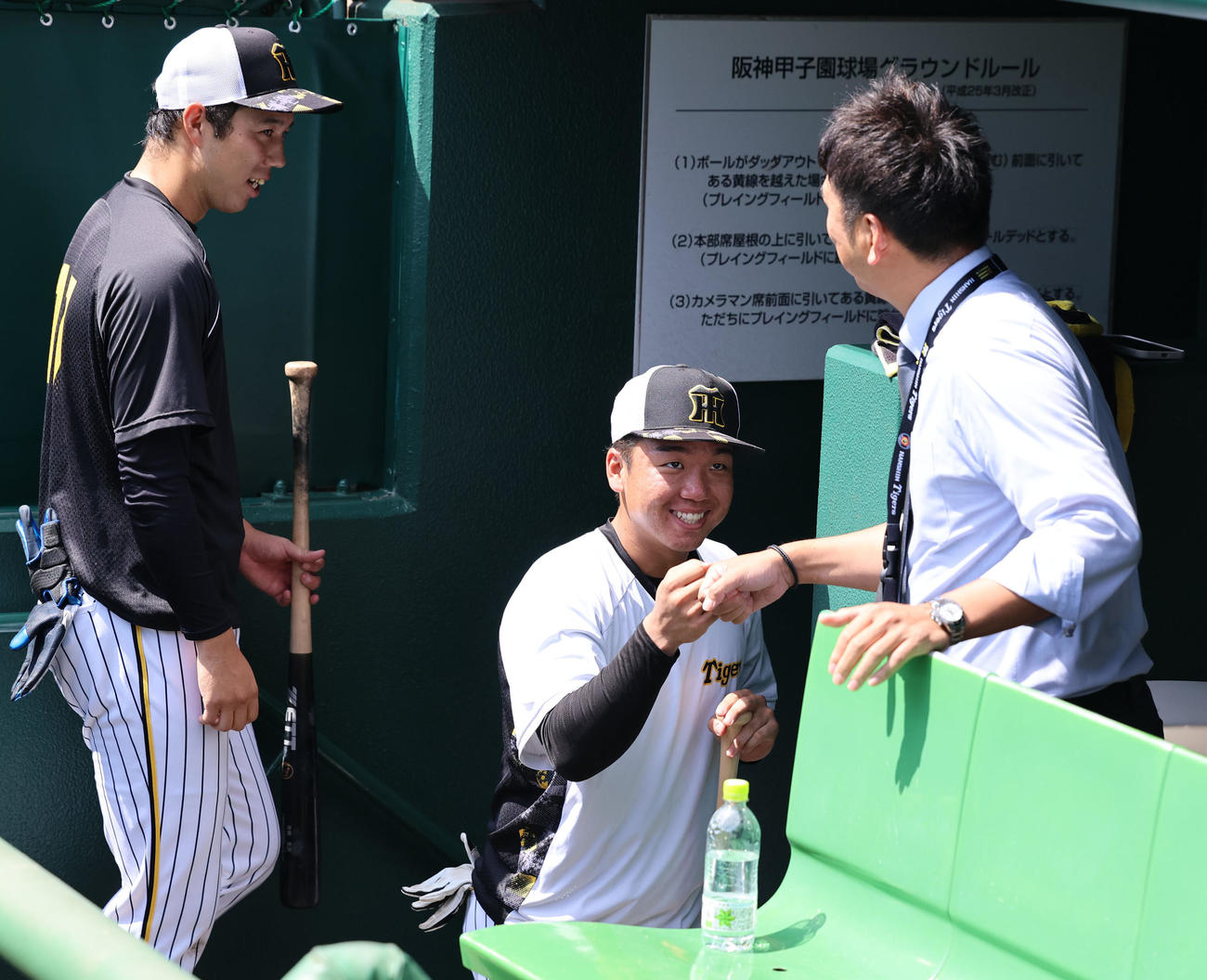 23年9月、甲子園を訪れた藤川氏（右）とグータッチする阪神村上。左は青柳