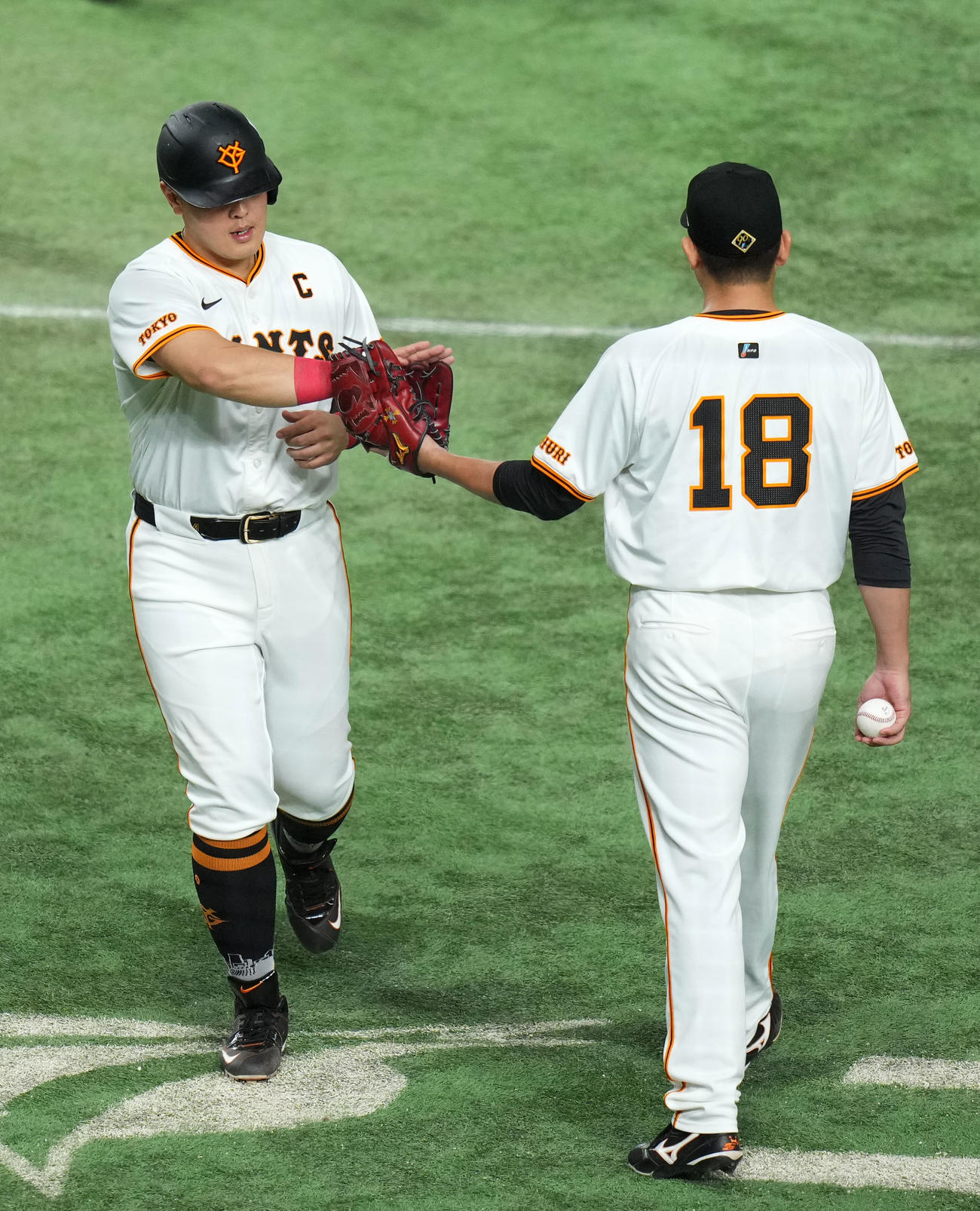 巨人対DeNA 6回裏終了後、菅野（右）とタッチを交わす岡本和（撮影・横山健太）