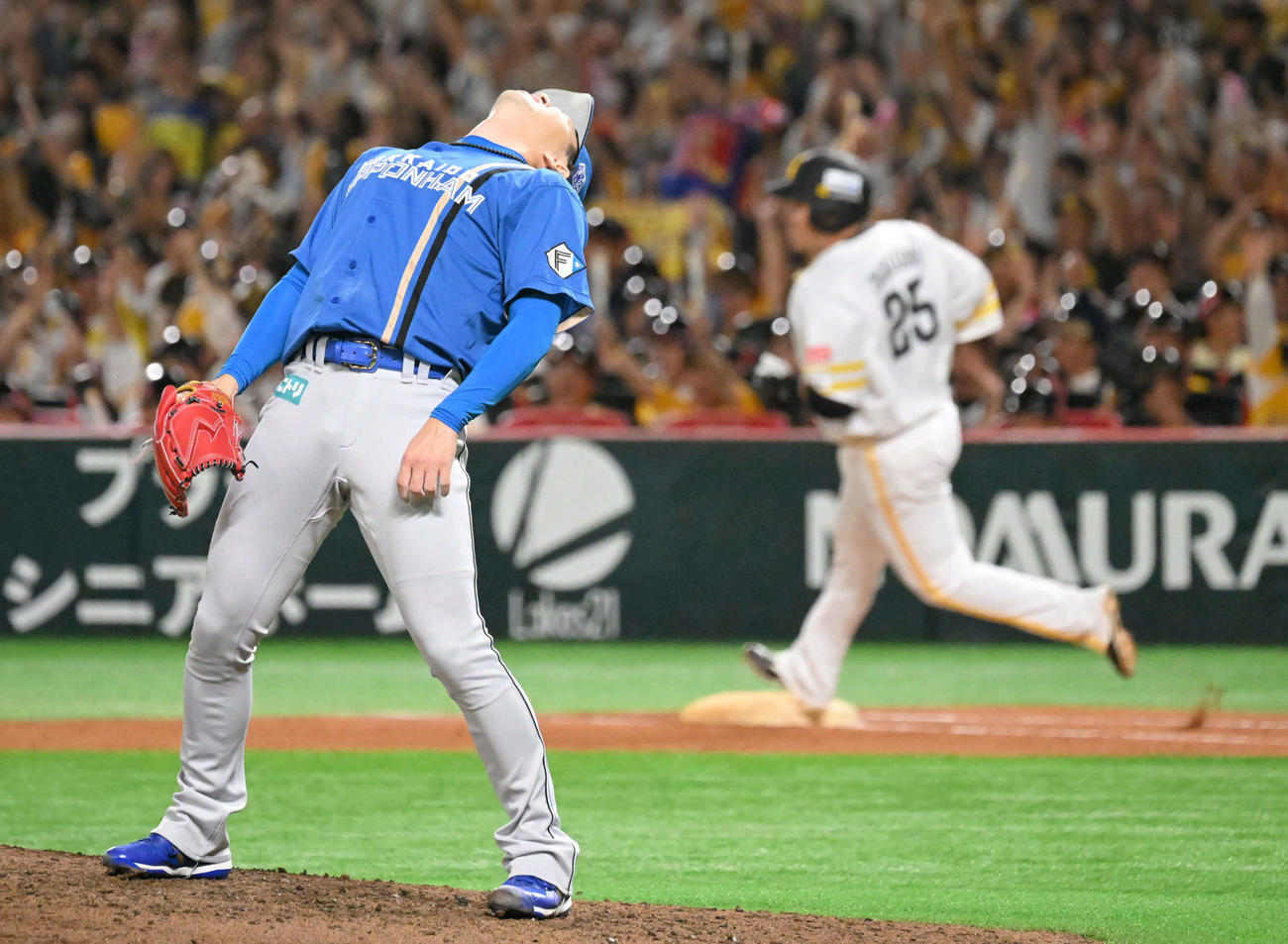ソフトバンク対日本ハム　5回裏ソフトバンク2死、山川（後方）にソロ本塁打を許した宮西は体を反らせて悔しがる（撮影・林敢治）