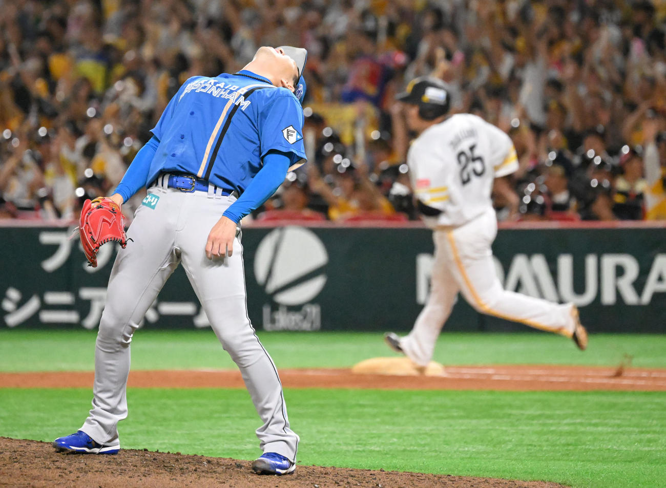 ソフトバンク対日本ハム　5回裏ソフトバンク2死、山川（後方）にソロ本塁打を許した宮西は体を反らせて悔しがる（撮影・林敢治）