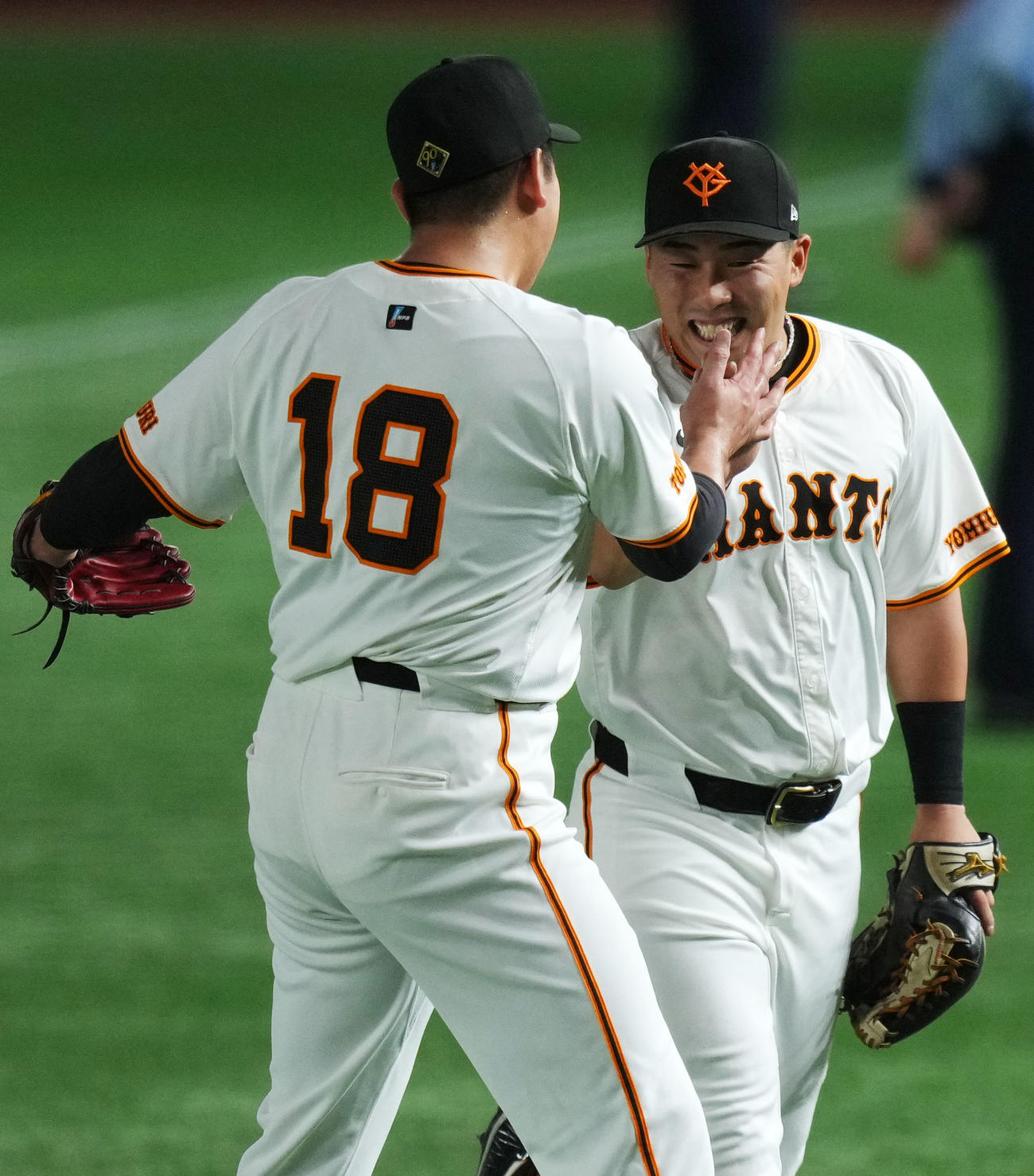 巨人対DeNA 2回表終了後、森の打球を好捕した浅野（右）は菅野と笑顔でタッチを交わす（撮影・横山健太）