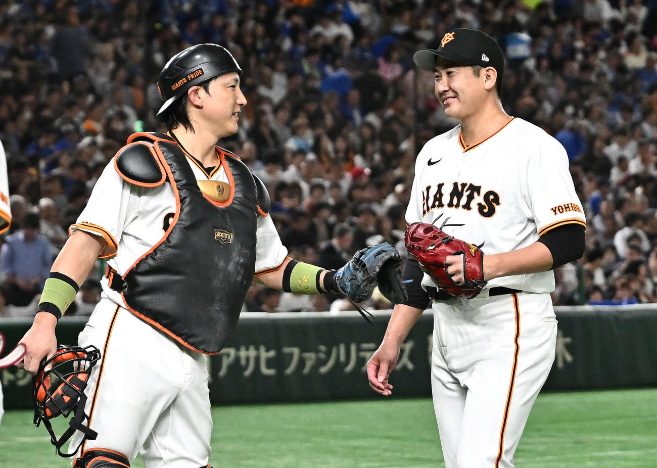 巨人対DeNA 7回表に追加点を許した巨人先発の菅野（右）は悔しげな表情で小林とタッチをかわす（撮影・滝沢徹郎）