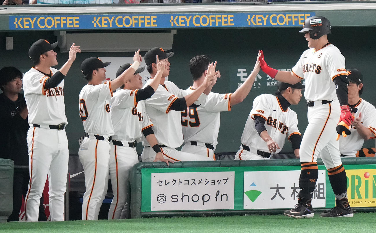 巨人対DeNA 2回裏巨人無死、先制の左越えソロ本塁打を放った岡本和（右手前）はナインと笑顔でハイタッチ（撮影・鈴木みどり）