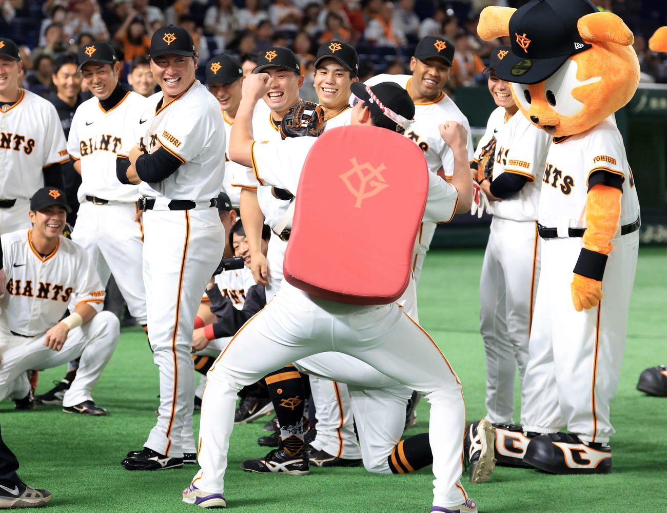 巨人対DeNA　巨人の試合前円陣の声出しに登場した赤いカバン？を背負った萩尾（手前）に爆笑する選手たち（撮影・浅見桂子）